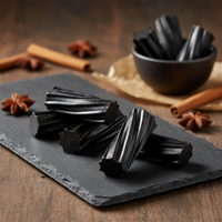 Aussie Style Black licorice from Tasty Treat, pieces on a slate board with cinnamon sticks and star anise in the background.